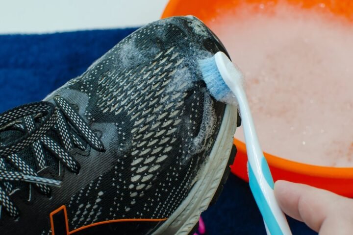 Running shoe being cleaned with a toothbrush