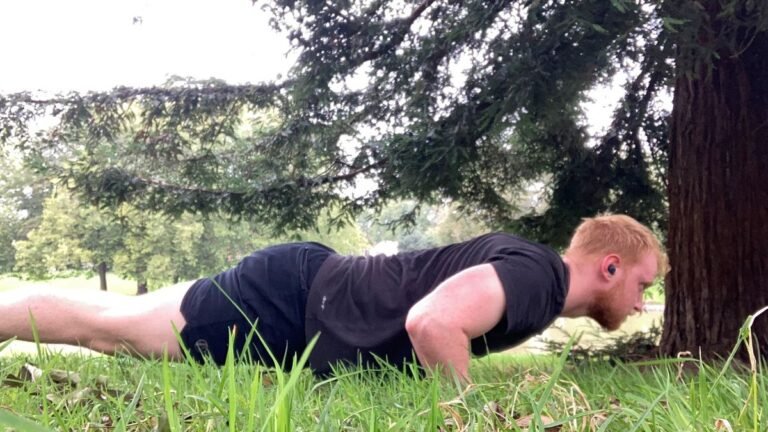 The author performs a push-up on grass