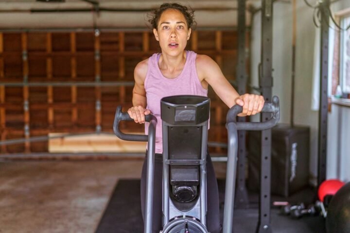 Woman riding air bike in garage
