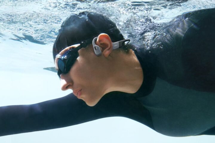 Swimmer wearing Shokz OpenSwim Pro headphones
