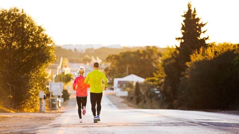 Man and woman seen from rear running downhill